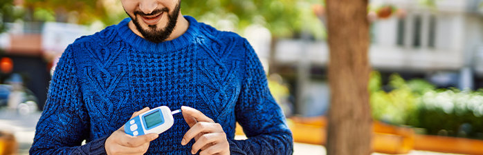 Man using glucose meter outside